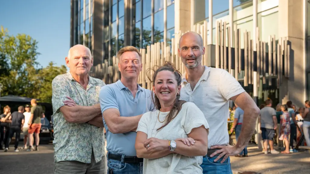 Ondernemers van Nest Werkplekken in Amstelveen staan samen buiten tijdens een bijeenkomst bij het kantoorgebouw.