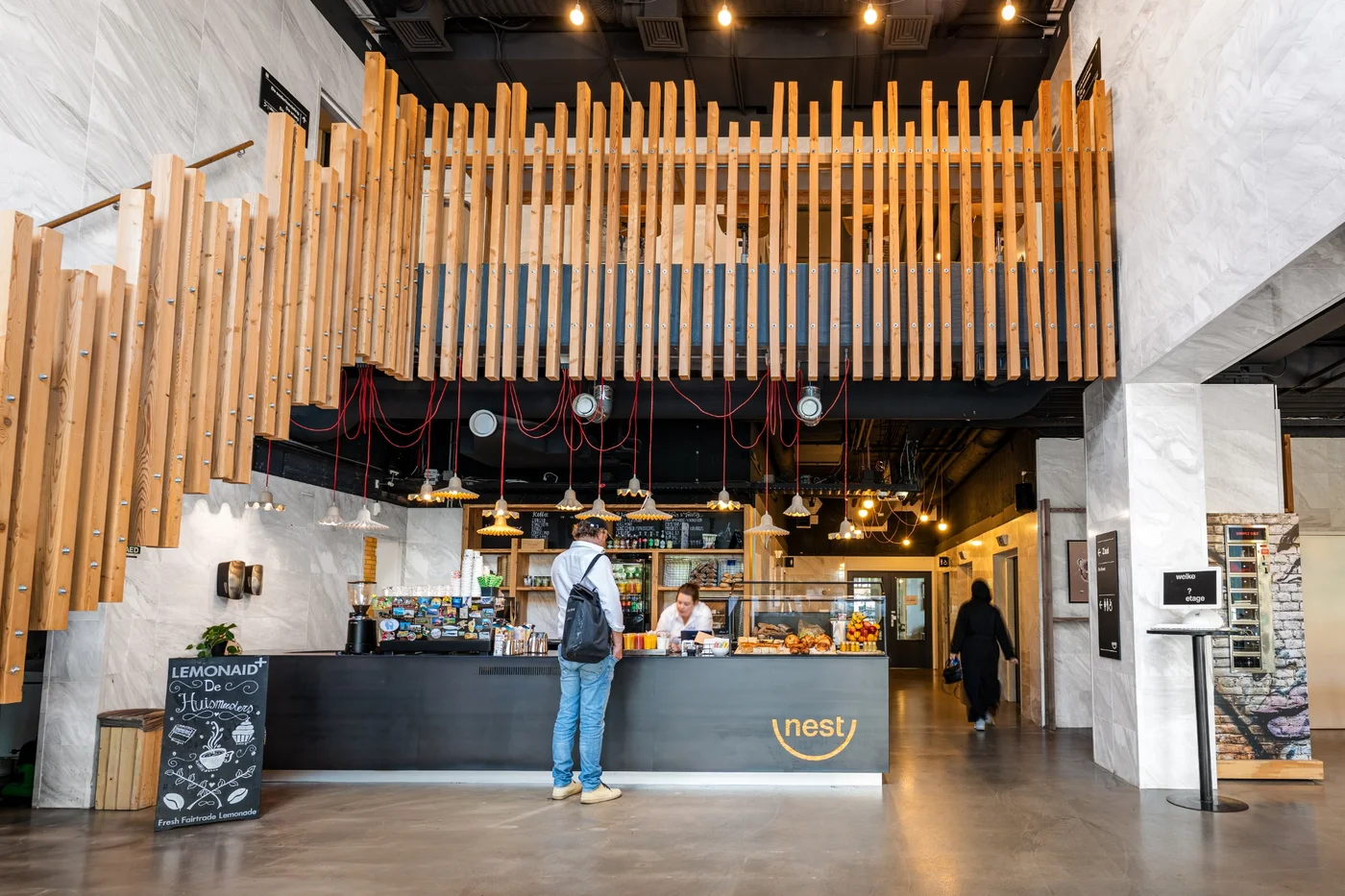 Entree van Nest Werkplekken in Amstelveen met koffiebar, houten interieur en ontvangstgedeelte