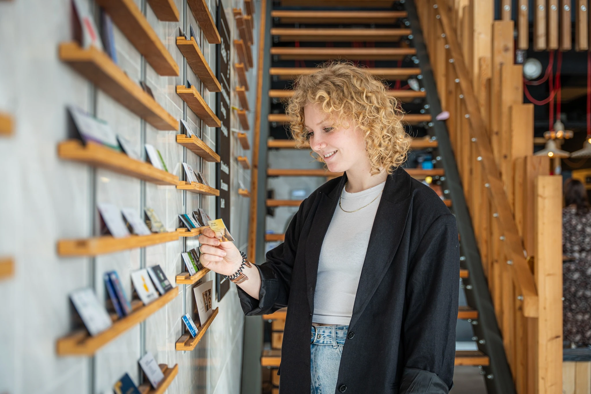 Ondernemer bekijkt visitekaartjes van andere bedrijven bij Nest Werkplekken in Amstelveen.