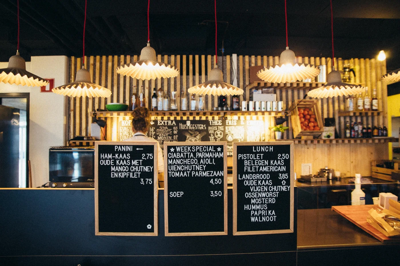 Horeca en koffiebar bij Nest Werkplekken in Amsterdam Zuidoost met menuborden, verlichting en zitgelegenheid