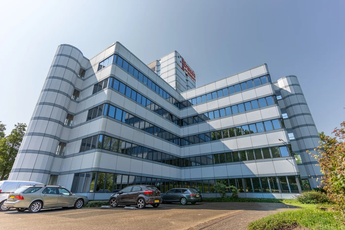 Exterieur van het kantoorgebouw van Nest Werkplekken in Amsterdam Zuidoost onder een heldere blauwe lucht